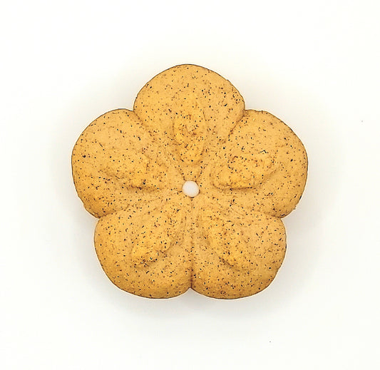 Flower-shaped cookie with a pearl in the center on a white background